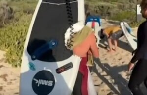 Schokkend moment dat een grote witte haai de surfer onder de golven sleept en een stuk uit zijn board haalt in een angstaanjagende aanval